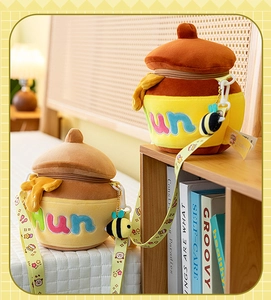 Detail of honey pot plush bag with cute bee charm and cartoon printed shoulder strap