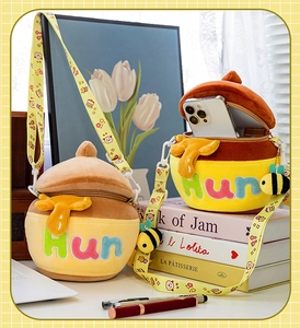 Detail of honey pot plush bag with embroidery, cartoon strap and a small bee charm