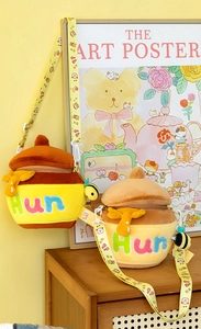 Detail of honey pot plush crossbody bags with cartoon straps and bee pendant decor