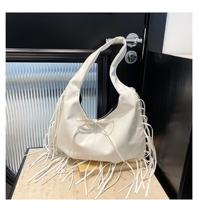 Détail du sac cabas en cuir PU blanc avec de longues franges latérales et un nœud central