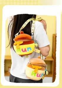 Detail of honey pot plush crossbody bag with bee charm and embroidered lettering
