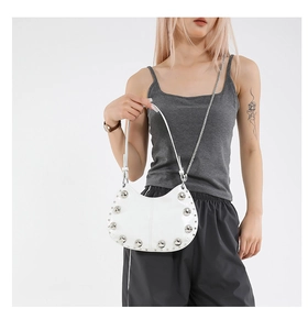 Sac hobo blanc avec grands rivets argentés et doubles bandoulières sur mannequin