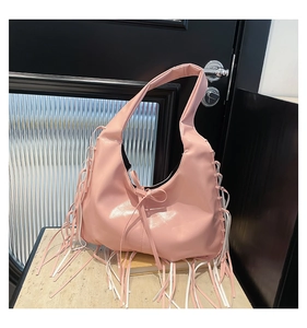 Détail du sac hobo rose avec de longues franges élégantes et un nœud décoratif