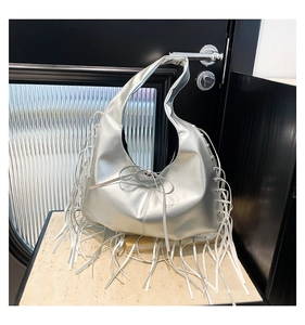 Détail d'un sac hobo argenté avec de longues franges et un petit nœud décoratif