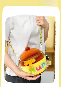Detail showing plush honey pot crossbody bag with bee charm and adjustable strap