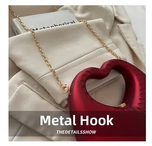 Detail of dark red heart bag showing the gold chain strap and metallic hardware hook
