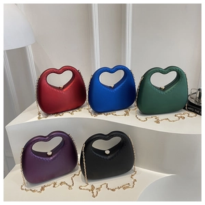 Detail of heart-shaped acrylic handbags in multiple colors with gold ball clasp hardware