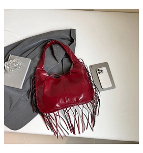 Détail du sac fourre-tout bordeaux brillant avec longues franges et nœud délicat