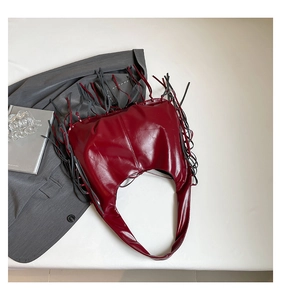 Détail du sac lune en PU brillant bordeaux avec de longues franges décoratives élégantes