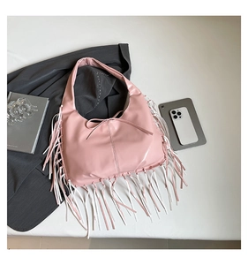 Détail d'un sac demi-lune en cuir PU rose avec de longues franges bohèmes et un nœud décoratif