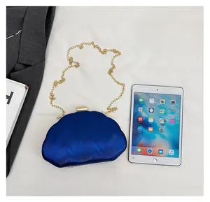 Blue acrylic shell evening bag showing size comparison next to a standard tablet device