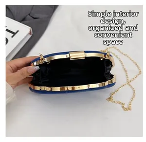 Interior detail of a navy blue shell clutch with satin lining and gold chain strap