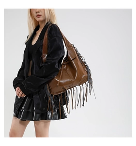 Détail d'un sac cabas en cuir marron avec de longues franges et un style bohème