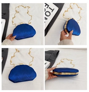 Detail view of royal blue satin shell clutch with gold metal frame and chain strap