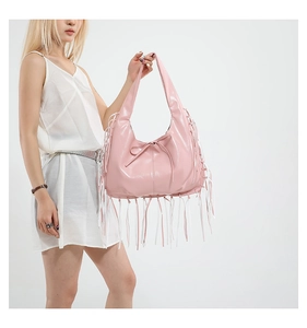 Sac fourre-tout rose brillant avec franges et nœud porté avec une robe blanche élégante