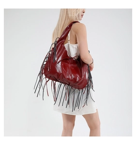Détail du grand sac cabas bordeaux avec de longues franges et une finition brillante