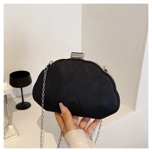 Detail of black pleated evening clutch with silver chain strap and metal clasp closure