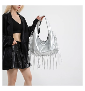 Sac à bandoulière argenté métallisé avec franges longues et nœud, porté par un mannequin