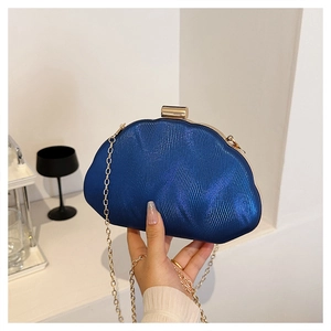 Detail of navy blue acrylic shell bag with wave texture and gold chain strap
