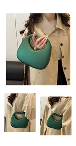 Detail of dark green heart-shaped handbag with matte finish and gold chain strap