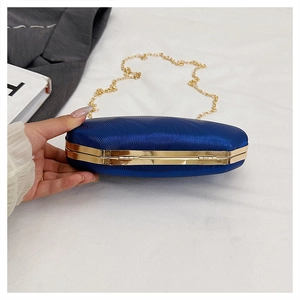 Close-up of royal blue evening clutch bag with ripple texture and gold chain strap