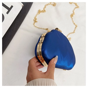 Detailed view of heart-shaped glitter dinner clutch with gold metal frame and chain