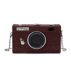 Fashionable burgundy camera-shaped crossbody bag with snakeskin texture and silver chain strap