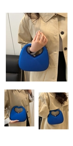 Close-up of royal blue heart-shaped cutout handbag with gold chain strap and metal clasp