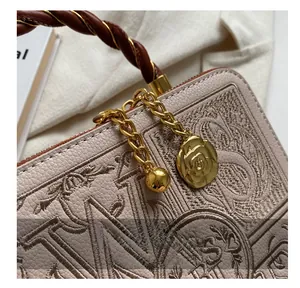 Macro detail of high-quality zipper and camellia charm on embroidered leather bag