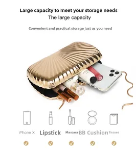 Interior view of shell-shaped gold clutch showing capacity for phone and cosmetics