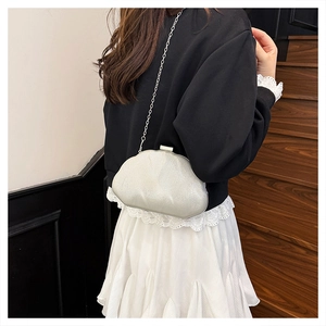 Detail of silver sequin cloud bag with metal chain shown on model in stylish setting