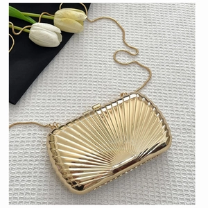Detailed view of golden shell-shaped evening clutch with metallic radial texture