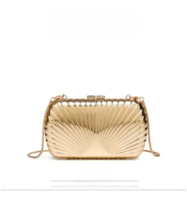 Detailed front view of shiny gold metallic evening bag with radial pleats and chain strap