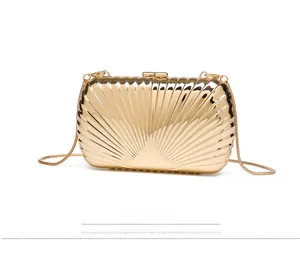 Detailed side view of golden shell-textured metal evening clutch with snake chain