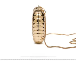 Detail view of gold metal box clutch showing horizontal wave texture and snake chain