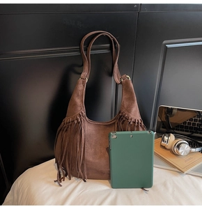 Macro shot of dark brown suede fringe tote bag detail with tablet for size comparison