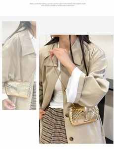 Detail of a metallic gold shell-shaped evening clutch bag with fine chain strap
