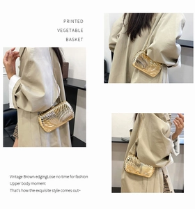 Detail of gold metal evening clutch with shell texture and fine chain strap in style