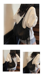 Close-up of black leather hobo bag featuring decorative long side tassels and stitching
