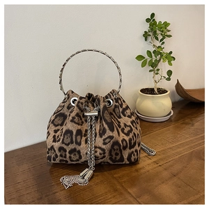 Close-up of leopard print bucket bag with silver metal handle on a wooden desk