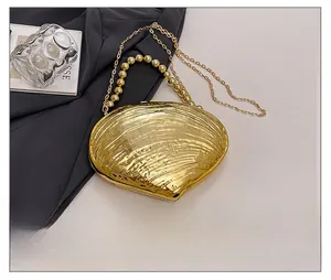 Detailed view of a golden shell evening clutch bag with metallic beads handle and chain