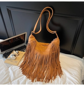 Detailed view of bohemian tan suede tassel crossbody bag with adjustable strap and laptop