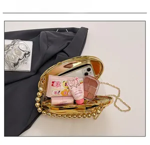 Detail view of gold shell evening clutch showing interior capacity for phone and cosmetics
