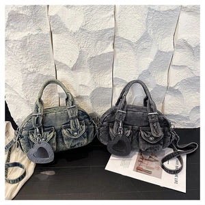 Detail of vintage denim handbags with dual front magnetic pockets and heart mirror charms