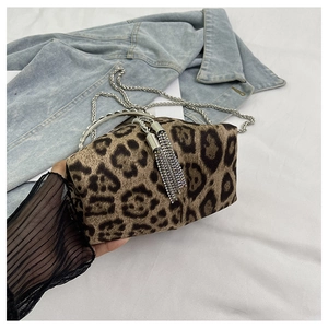 Detail of leopard print bucket bag featuring silver metal handle and sparkling rhinestone tassels