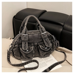 Detail view of dark grey washed denim bag with front buckle pockets and hardware