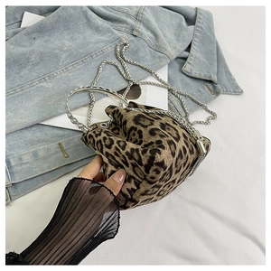Detail showing the leopard print fabric texture and silver metal ring handle on bucket bag