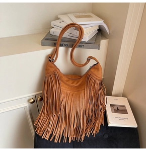 Detailed view of the bohemian tan suede hobo bag with fringe and metal zipper closure