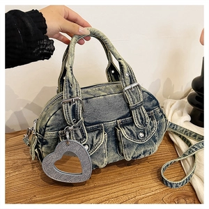 Detail of vintage denim tote bag with heart mirror charm and silver buckle pockets