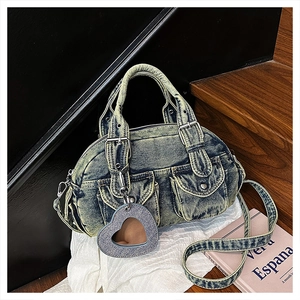 Detail of vintage washed blue denim handbag featuring cargo pockets and heart mirror charm